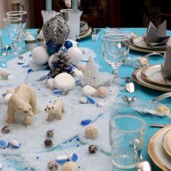 Centre de table en boules et décorations de Noël aux tons assortis et figurines d'ours polaires.